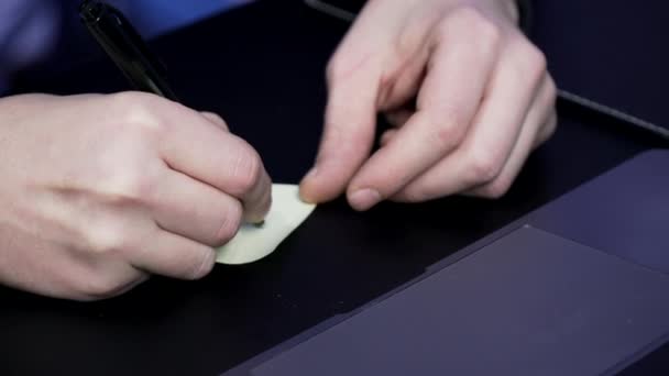 Mão masculina escreve em um adesivo — Vídeo de Stock