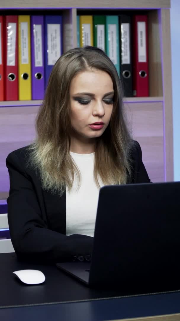Vídeo vertical. Menina europeia está digitando texto no laptop — Vídeo de Stock