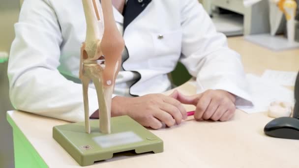 As mãos dos médicos estão segurando uma caneta. mockup articulação do joelho — Vídeo de Stock