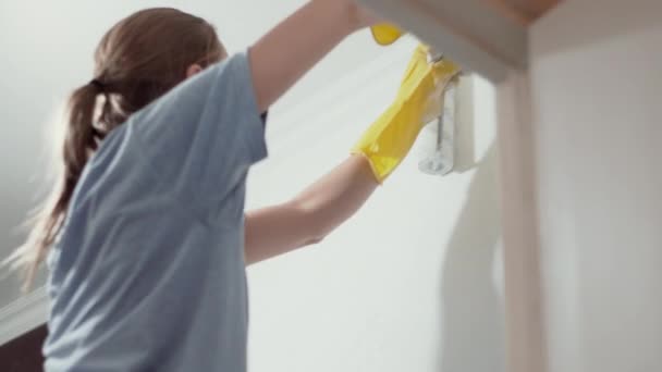Blank meisje schildert de muren met een roller — Stockvideo