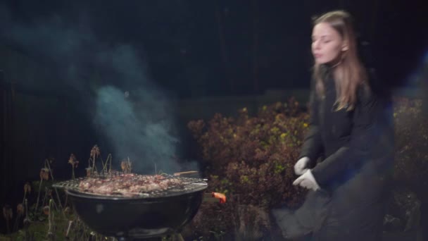 Fille frites un barbecue et ventilateur le feu — Video