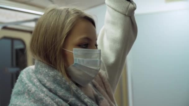 Meisje in een medisch masker staan in een metro auto — Stockvideo