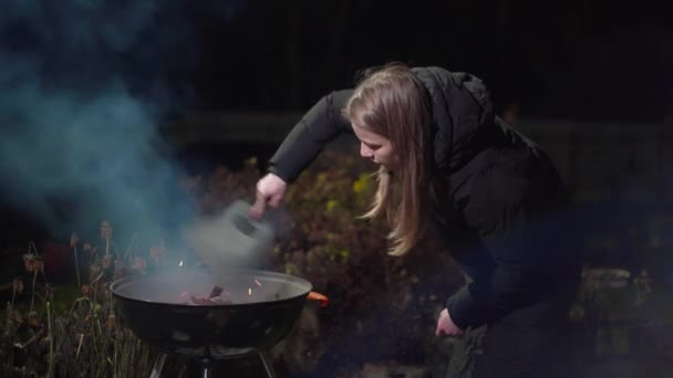 Chica en una chaqueta negra hace un fuego — Vídeos de Stock