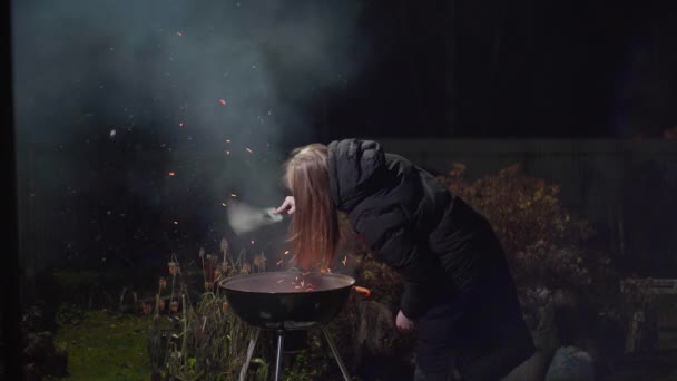 Menina em uma jaqueta preta faz um fogo — Vídeo de Stock