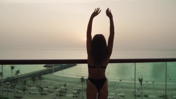 Girl in a swimsuit raises her hands up — Video