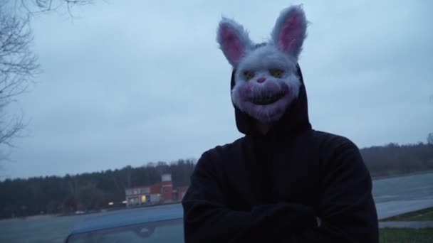 Scary evil maniac in a rabbit mask looks at the camera and prepares to kill — Stok Video