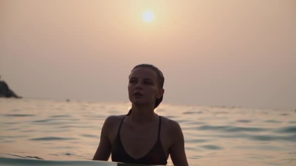 Girl bathes in the sea against the backdrop of the sunset — Stock Video