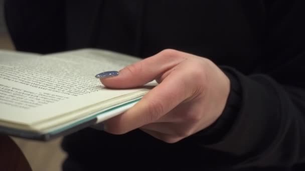 Egy női kéz nyitott könyvet tart. — Stock videók