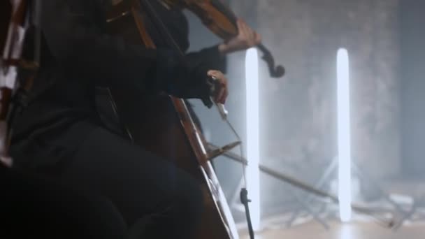 Mujer en un suéter negro toca el violonchelo — Vídeo de stock