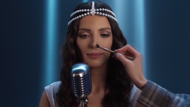 The singer gets makeup. The make-up artists hand corrects the make-up. — Stock Video