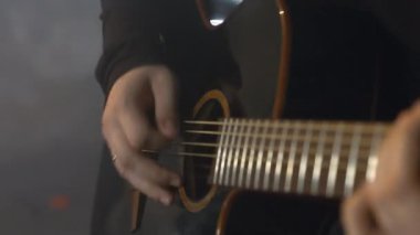  Siyah kazaklı adam akustik gitar çalıyor.