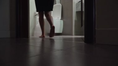  Kız tuvalete gider ve tuvalette oturur. Kadın tuvalete işiyor.
