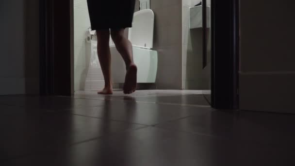 Mädchen geht ins Badezimmer und setzt sich auf die Toilette. Frau pinkelt in die Toilette — Stockvideo