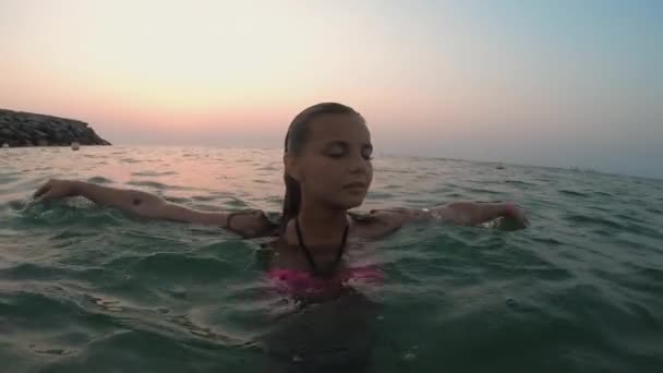 Staat in het water heft haar handen omhoog — Stockvideo