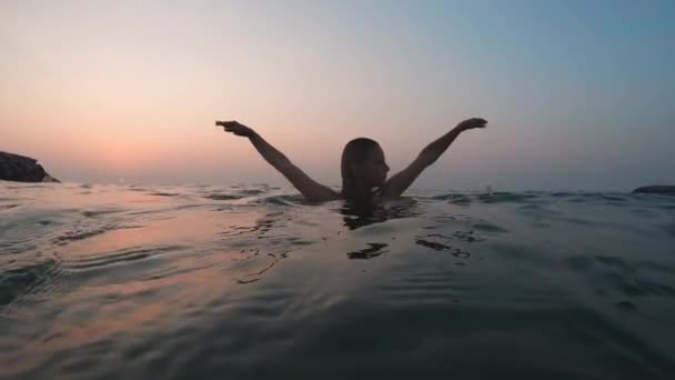 Staat in het water heft haar handen omhoog — Stockvideo