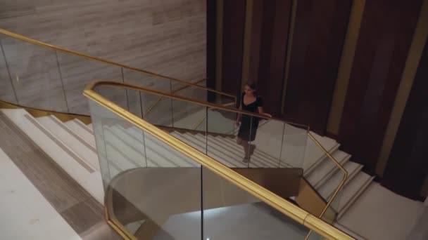 Dziewczyna w pięknej sukni wieczorowej idzie po schodach — Wideo stockowe