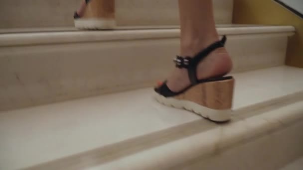 Pés de mulher em sandálias sobem as escadas. Sandálias de cunha — Vídeo de Stock