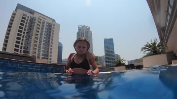 Dziewczyna siedząca w basenie na dachu w Dubaju — Wideo stockowe