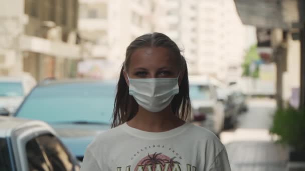 Una mujer en un país caliente está de pie en una máscara en la calle — Vídeos de Stock