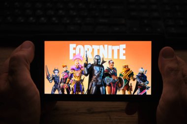 Kostanay, Kazakistan, Kasım 01, 2021 Popüler oyun Fortnite 2 'nin ekran koruyucusuyla cep telefonu tutan adam.