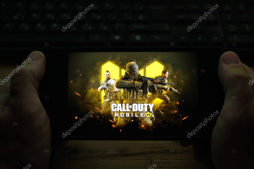 Kostanay, Kazakhstan, November 04, 2021.A man holds a mobile phone with a screensaver of the popular Call of Duty game