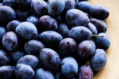 Pencereden gelen ışıkta olgun erikleri tabağa koy