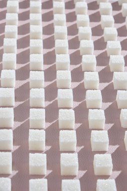 Rafine şeker pembe bir arka plan üzerinde. Küp geometricshape, tatlı ve beyaz şeker. Sert gölgeler