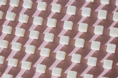 Rafine şeker pembe bir arka plan üzerinde. Küp geometricshape, tatlı ve beyaz şeker. Sert gölgeler