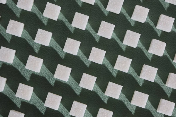緑色の背景に精製された砂糖 幾何学的な形で甘いと白の砂糖のキューブ 固い影 — ストック写真