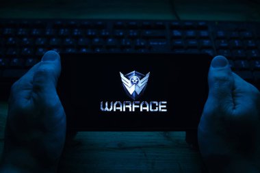 Kostanay, Kazakistan, Kasım 02, 2021 Elinde ekran koruyucu logosu popüler Warface oyunu olan cep telefonu