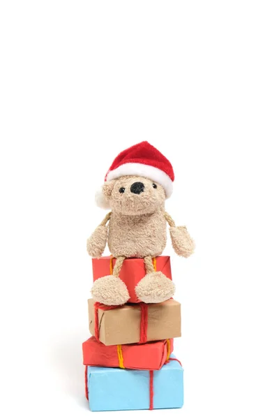 Kleiner Teddybär Mit Nikolausmütze Sitzt Auf Schachteln Mit Weihnachtsgeschenken — Stockfoto