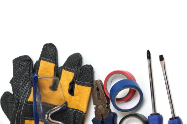 Beyaz arka planda, tornavidalar, koli bandı, pense ve güvenlik gözlükleri.