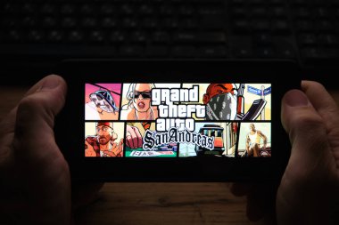 Kostanay, Kazakistan, Kasım 04, 2021 Bir adam ünlü Grand Theft Auto 'nun ekran koruyucusunu elinde tutuyor: San Andreas