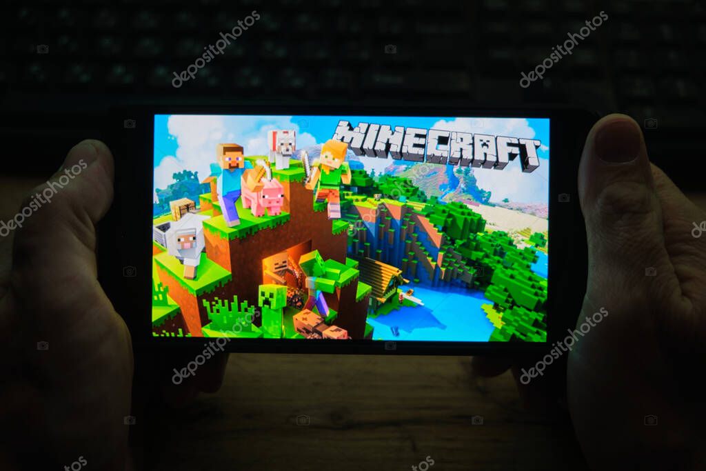 Kostanay, Kazakhstan, November 04, 2021.A man holds a mobile phone with a screensaver of the popular Minecraft game