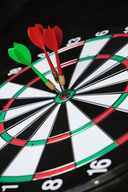 Rekabet ve hedefe ulaşma kavramı. İş ve hayatta hedeflere ulaşmak. Hedefin tam ortasına üç ok saplanmış bir dart tahtası.