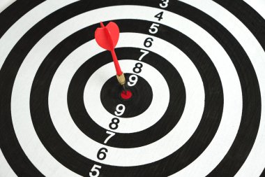 Rekabet ve başarı hedefleri. İş ve hayatta hedeflere ulaşmak. Hedefin tam ortasına ok saplanmış bir dart tahtası.