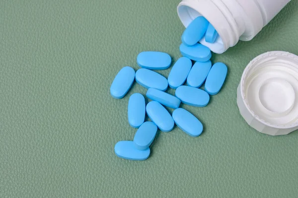 Scattering Blue Pills Bottle Green Background Top View — Stock Photo, Image