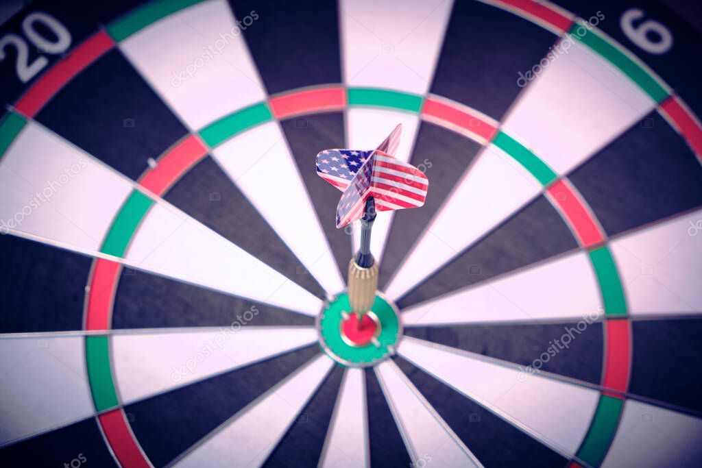 Concept achieving goal .Achieving goals in business and life.Dartboard with dart stuck right in center of target