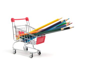 Beyaz bir arka planda alışveriş arabasında renkli kalemler. Okul malzemeleri çizmek için.