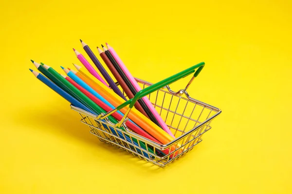 黄色の背景にショッピングカート内の色鉛筆 — ストック写真
