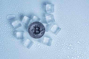 Bitcoin para orta eritme buz küpleri ve hafif arkaplan üzerine su damlaları