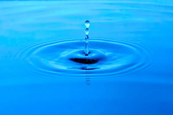落下後のスプラッシュ水 水の落下と青の抽象的な背景 — ストック写真