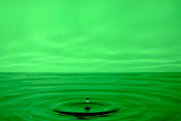 落下後のスプラッシュ水 水の落下と緑の抽象的な背景 — ストック写真