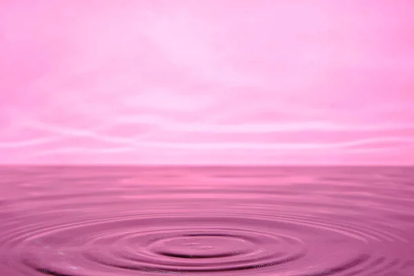 Leuchtend Rosa Hintergrund Mit Abweichenden Kreisen Von Tropfen Auf Oberflächenwasser — Stockfoto