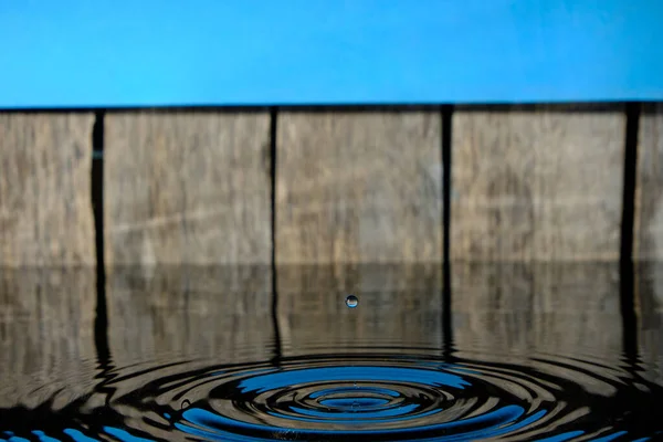 Cerchi Spruzzi Acqua Gocce Pioggia Sfondo Vecchio Recinto Cielo Blu — Foto Stock