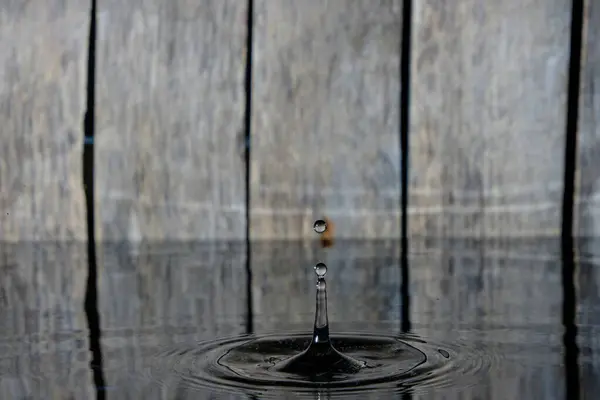 Rozprysk Fale Wodzie Opadającej Kropli Deszczu Drewnianym Tle — Zdjęcie stockowe