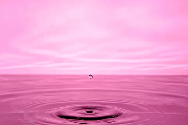落下後のスプラッシュ水 水に落ちるピンクの抽象的な背景 — ストック写真