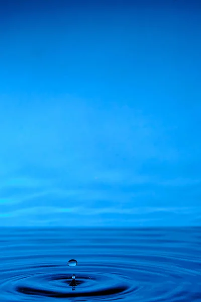 雨が降った後に水が噴き出す 水の滴と青の抽象的な背景 — ストック写真