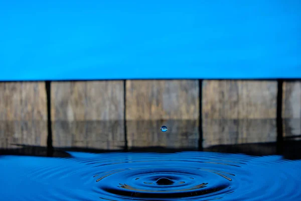 Cerchi Spruzzi Acqua Gocce Pioggia Sfondo Vecchio Recinto Cielo Blu — Foto Stock