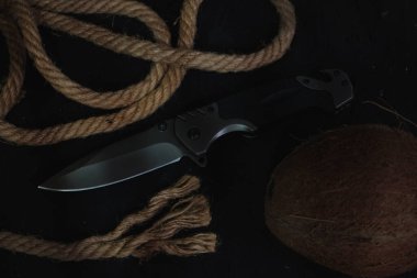 Hayatta kalmak için taktik katlama bıçağı, aktif yaşam tarzı ve eğlence, halat arka planda ve karanlık arka planda